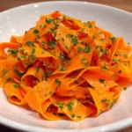 Retinol carrot salad in white bowl with scallions and sesame
