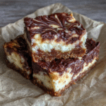 Sliced cottage cheese fudge on parchment with melted chocolate